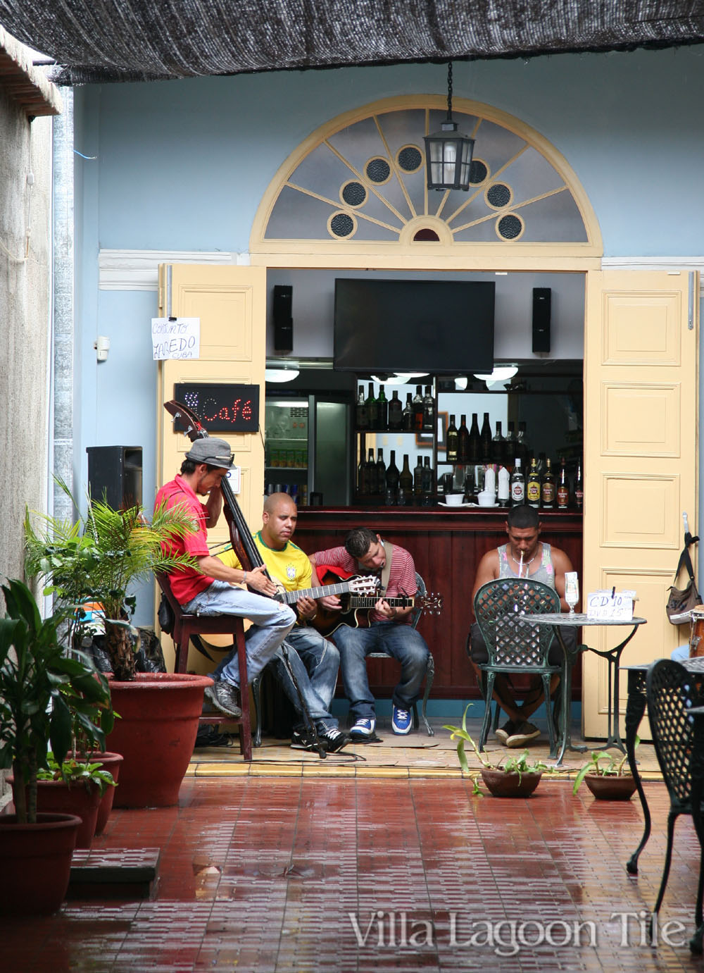 Cuban musicians have gathered down a long cement tile hallway just after a quick rain.